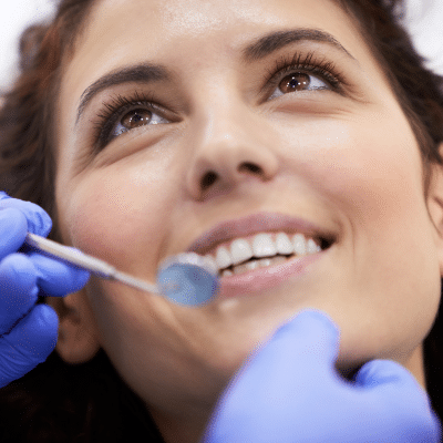 Woman at the dentist getting her teeth checked, representing routine dental cleaning