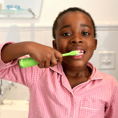 Little kid brushing their teeth, representing how to care for childrens teeth at home