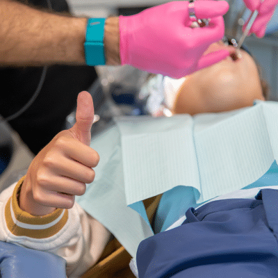 Patient giving a thumbs up while receiving dental work at ashburn dentistry by design, representing the benefits of porcelain veneers
